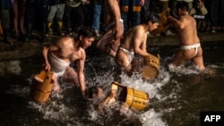 Men cleanse their bodies in a river during the Sominsai Festival at Kokuseki-ji Temple in Oshu, Iwate Prefecture, Japan, Feb. 17, 2024.