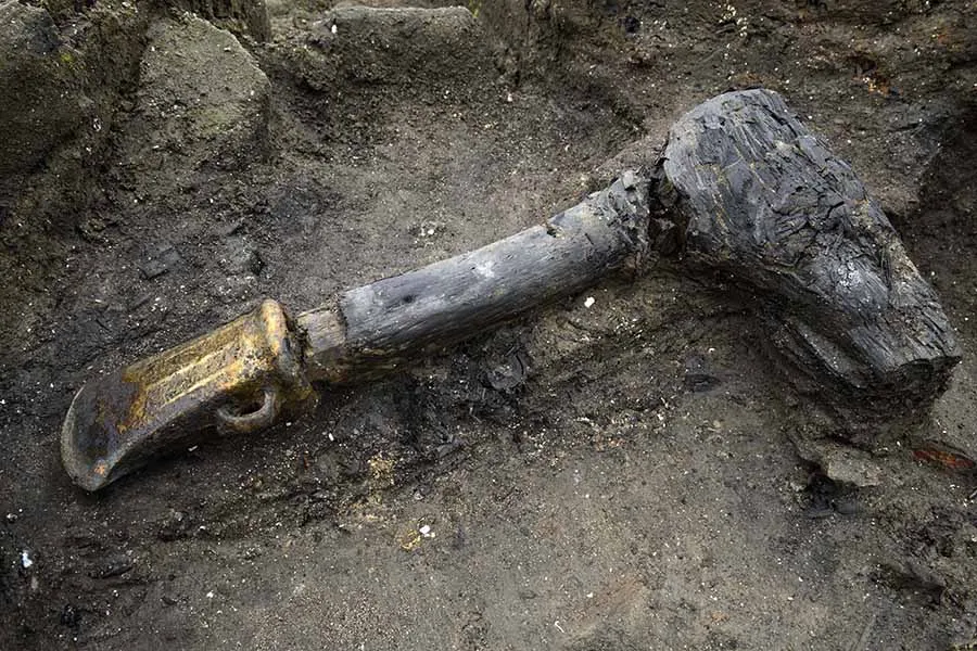 a scorched axe in dirt